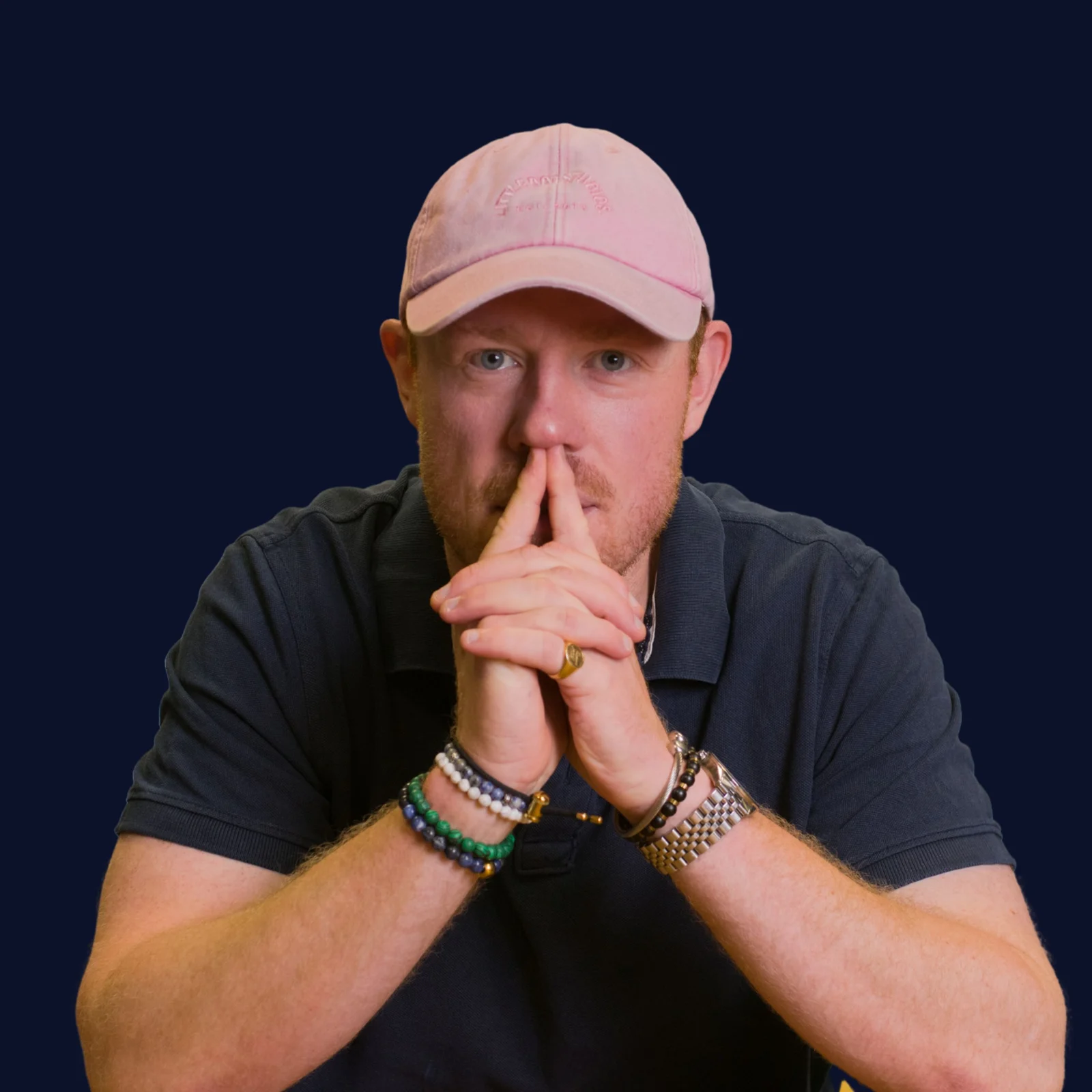 Oliver Bruce wearing a pink cap, looking directly at the camera
